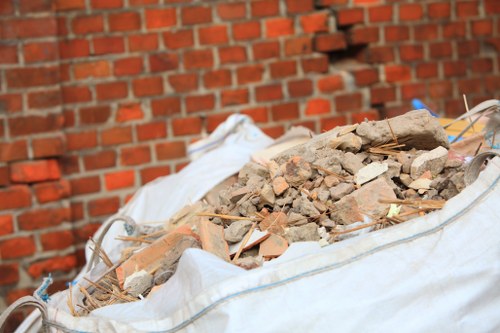 Construction site with builders managing waste clearance in Chigwell